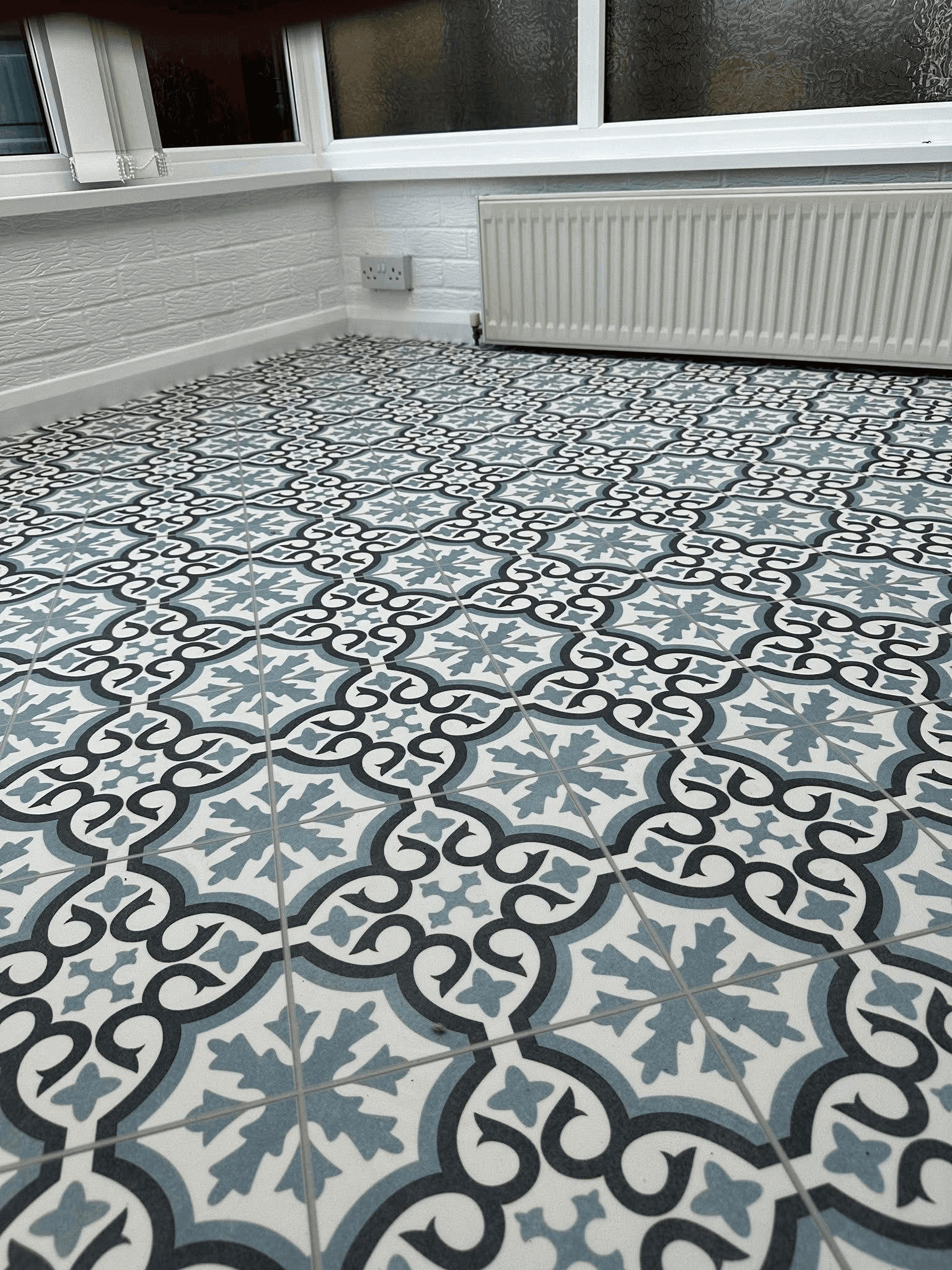 Decorative geometric blue and white vinyl tiles fitted in conservatory