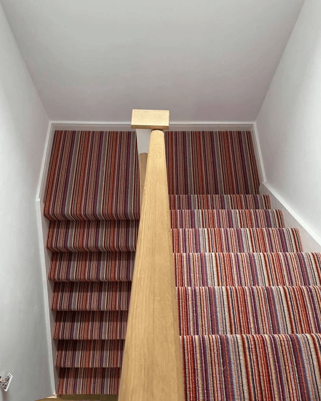 Vibrant multicolour striped carpet fitted on straight staircase